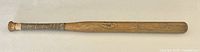 Full length view of the wooden bat showing the leather wrapped handle and overall wood body.
