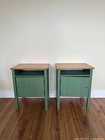 Two green bedside tables with light brown tops, showing front view with cabinet doors closed