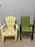 Photo showing one yellow plastic Adirondack chair and one green mesh sling garden chair side by side