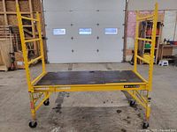 Full assembled scaffold showing platform, guardrails, frames, and casters