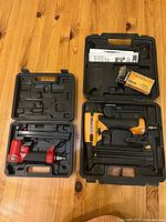 Open cases displaying red DP-50 pneumatic staple gun in left case and yellow/black Bostitch BT1855K brad nailer in right case