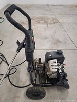 Front-side view showing engine, pump assembly, frame and handle