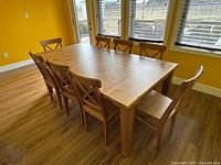 Angled front view of the full dining set showing table top and eight chairs