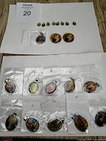 Overview of the pendants including small, medium and large sizes, some still in original packaging, laid out on white background.