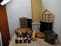 Photo showing entire lot on wooden surface against white backdrop, including shelves, furniture legs, elephant figurines, and various wood items.