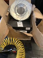 Open box showing two new silver disc brake rotors and black boxes inside packaging.