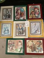 Full set of eight framed clown art prints laid out for display. Frames are colorful and glass needs cleaning.