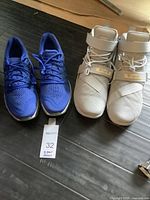 Photo showing both pairs of sneakers side by side on floor with size note card