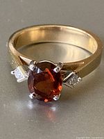 Front view of ring showing round garnet and diamond accents