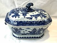Front view of tureen with lid on showing octagonal shape and overall blue landscape motif