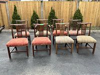 Front view of all eight chairs showing two armchairs in back row center and mixed upholstery