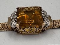 Close-up of rectangular citrine and surrounding filigree with diamonds