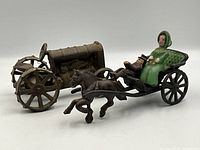 Side view of antique cast iron horse and buggy toy showing horse in mid-gallop and two painted figures seated in buggy with green and brown paint.