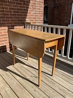 Full view of the drop-leaf table with one leaf down.