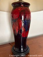 Lamp base on wooden surface, showing overall profile and pattern on dark background