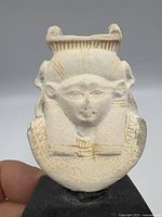 Artifact front view held by hand against neutral background, scale reference.