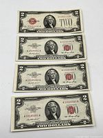Four USA 1953 Series 2 two dollar bills front view showing portraits of Thomas Jefferson and red Treasury seals, with serial numbers visible.