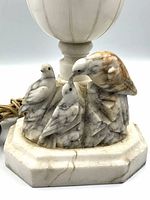 Close-up of carved bird family on octagonal alabaster base