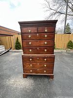 Full view of the large Georgian mahogany chest on chest showing two-piece construction, brass hardware, dentil cornice, and bracket feet.