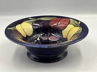 Front angle of the footed bowl showing Wisteria motif and dark blue background