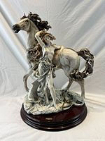 Front view of porcelain figurine with horse and woman on wood base