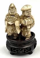 Front view of netsuke figurine on wooden stand showing both figures