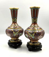 Pair of cloisonne vases on carved wooden stands, front view