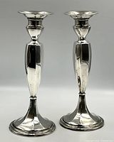 Front view of the pair of candlestick holders on plain gray background