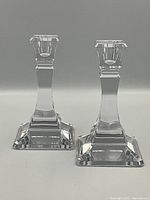 Two candlestick holders on neutral gray background showing front elevation