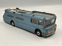 Front and side angle showing blue metal transporter with 'Ecurie Ecosse' lettering, some paint wear and detail of front grille and windows.