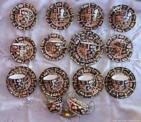 Top-down view of all cups, saucers, plates, creamer and sugar bowl arranged on cloth