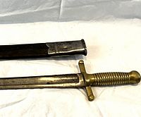 Close-up of brass handle, straight crossguard and scabbard throat fitting