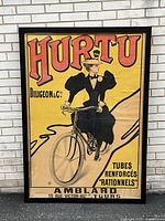 Full view of framed poster leaning against a white brick wall