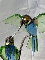 Close-up showing faceted crystal details of bird heads and bodies