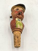 Front view of vintage hand-carved mechanical bottle stopper with painted face and cigar.