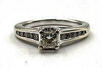 Front view showing princess-cut center diamond and channel-set side stones