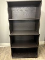 Front view of the IKEA black-brown bookcase showing four shelves including adjustable lower shelf.