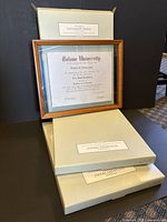 Three original boxes of document frames with cherry finish, unopened except one opened for photo. One framed diploma shown for display example.