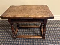 Front angled view of the wooden coffee table showing carved accents and turned legs