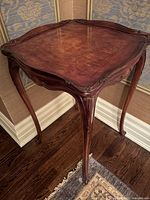 Front angled view of table showing carved top and legs