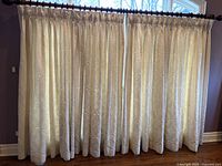 Curtains fully drawn, showing matelassé quilted cotton cream curtains gathered on rod, length to floor