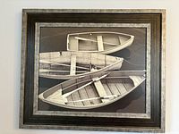 Full view of the framed black and white rowboat print showing three boats in a horizontal arrangement with a black-brown frame and grey-toned trim.