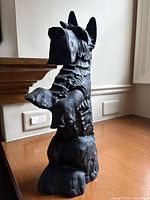 Side view showing detailed front of the black iron Scottie dog figurine with raised front paws.