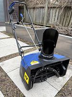 Front-right angled view showing housing, chute, handle and wheels