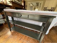 Front angled view showing drawer, shelves, and distressed edges