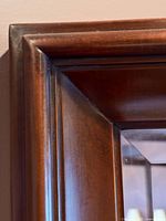 Close-up of the mirror frame corner showing smooth, polished maple wood with subtle detailing.