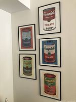 Five framed Campbell Soup prints arranged on the wall showing different color variations.