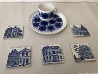 Five Delft ceramic coasters with blue drawings of old Dutch buildings, KLM Airlines vintage collectibles.