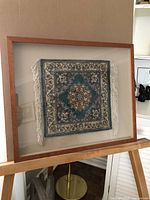 Full view of framed shadow box Asian rug showing detailed pattern and wood frame.