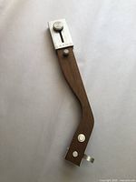 Full view of vintage Grado teak wood tonearm with metal adjustment knobs and natural wood grain visible, showing overall shape and condition.